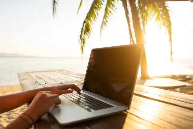 mit dem Computer am Strand
