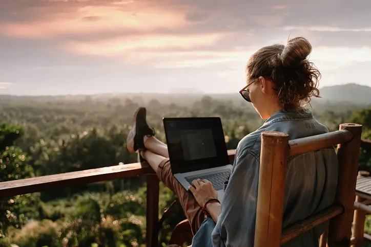 Frau arbeitet mit dem Computer auf der Veranda